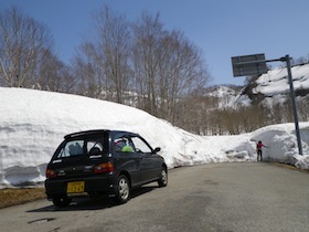 雪の路肩に停車する黒い車