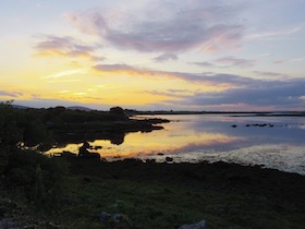 黒い岩の浜辺の夕焼け