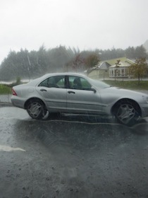 雨に降られるグレーの車