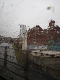 雨の車窓から見る赤煉瓦の建物