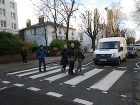 アビイ・ロードの横断歩道で写真を撮る四人組