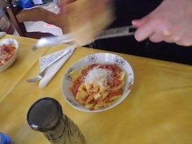 パスタの上にチーズをおろす