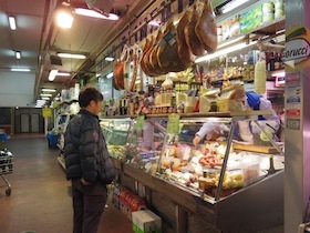 生ハムが吊るされている店の前にいる男性