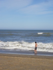 波打ち際に足を浸ける男性