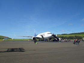 滑走路に停まる飛行機と降りる人々