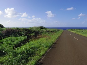 草原の中に海に向かって伸びる一本道