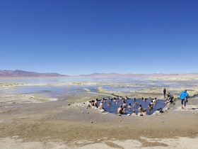 砂漠の中の温泉に入る人達