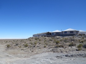 青空と大地の上の白い平家の建物