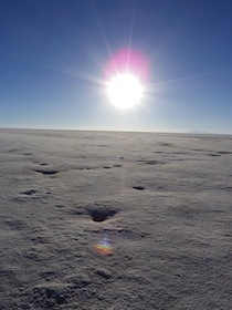 光り輝く太陽が登る青空と白い大地