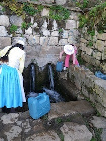 石垣の中にある水汲み場と水を汲む人達