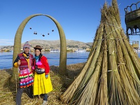 藁の小屋と民族衣装を着た男女