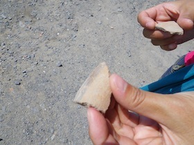 陶器の欠片の遺跡を持った手