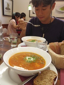 丼に入ったスープを食べる男性