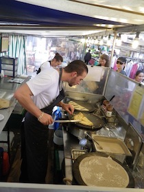 屋台でクレープを焼く男性