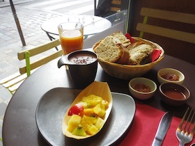 カフェのテーブルに並んだパンとドリンクとフルーツ