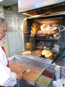 グリル機で肉を焼く男性