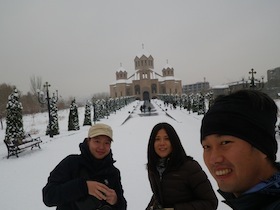 雪景色の教会の前にいる男女三人