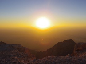 岩山が見える地平線に沈む夕陽