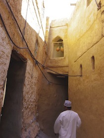 石造りの建物の下の通路を歩く人