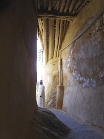 建物の下の路地に立つ男性