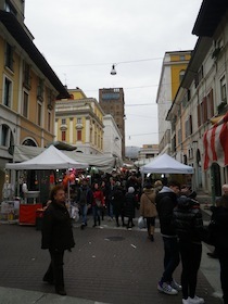 道路に露店が出て人が集まっているイタリアの街並み