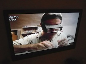 ゴーグルをつけて作業する職人が映るテレビモニター