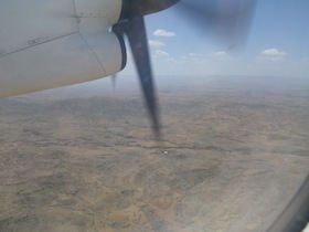 飛行機のプロペラと下に見える大地