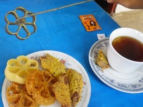 青いテーブルの上の揚げ菓子と紅茶