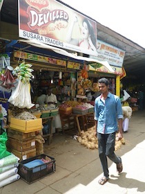 食料品店とその前を歩く男性