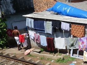 洗濯物が干された小屋と上半身裸の男性