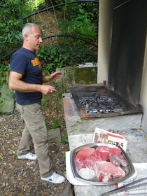 炭火で肉を焼こうとする男性