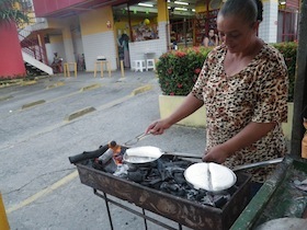 屋外で白い生地を焼く女性