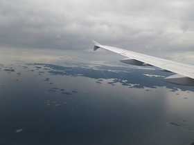 上空を飛ぶ飛行機の羽の一部