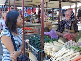 野菜を売る女性と話す女性客